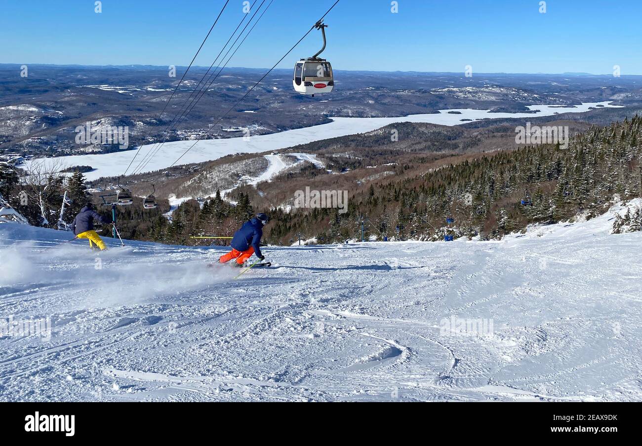 Skifahrer auf Mont Tremblant Pisten mit Gondeln im Hintergrund, Quebec, Kanada Stockfoto