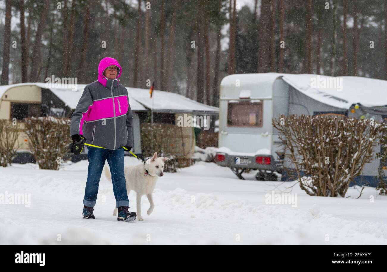 Wietzendorf, Deutschland. Februar 2021, 08th. Dauercamper Margret Streb  geht mit ihrem Hund über das Gelände des Südsee-Camps. Im Winter gibt es  wenig Aktivität auf Campingplätzen, nur ein paar ganzjährige Bucher sind zu
