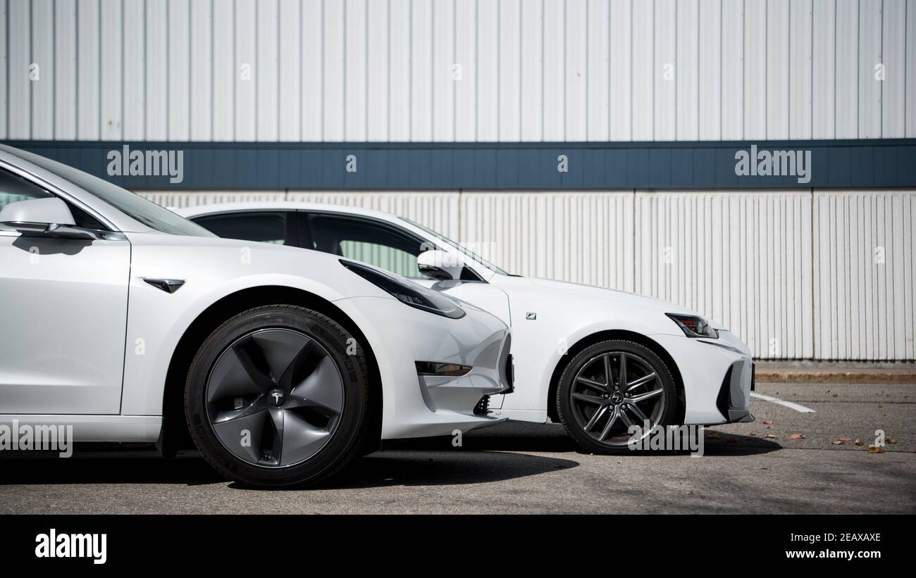 lexus IST und tesla Modell 3 nebeneinander geparkt, bereit zum Rennen Stockfoto