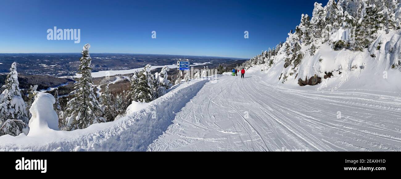 Panorama-Luftaufnahme von Mont und Lake Tremblant im Winter mit Skifahrern auf Piste Abfahrt, Quebec, Kanada Stockfoto