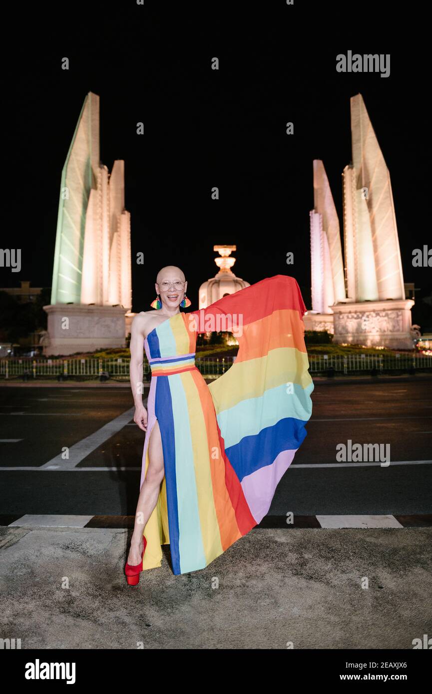 Ein LGBTQ-Aktivist in einem Kleid mit Regenbogenfarben, um die Unterstützung der LGBTQ-Gemeinschaft vor Bangkoks Demokratie-Denkmal zu demonstrieren. Stockfoto