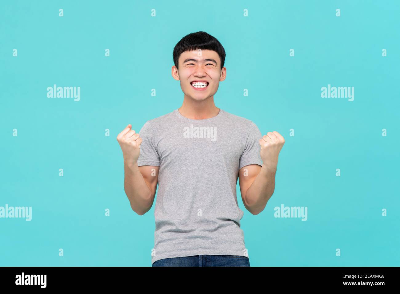 Glücklich, aufgeregt junger asiatischer Mann hob seine Fäuste tun ja Geste Erfolge feiern Stockfoto