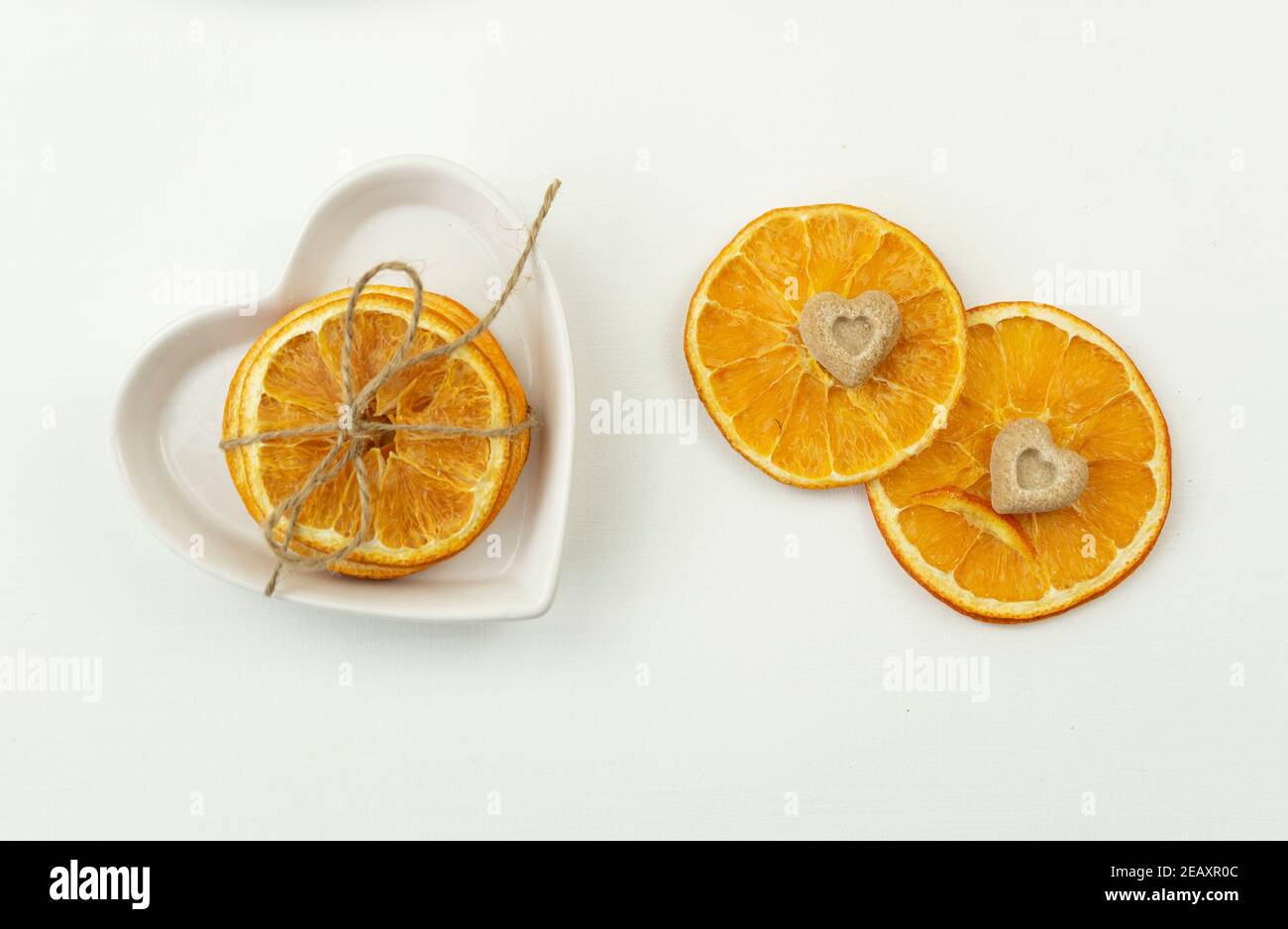 Getrocknete Orangen mit braunem Zucker in Form der Das Herz liegt auf einem weißen Teller Stockfoto