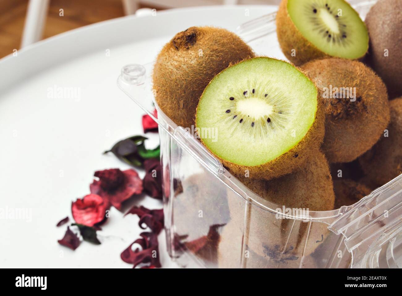 Frische grüne reife Kiwi-Frucht ganz und in Behälter geschnitten Stockfoto