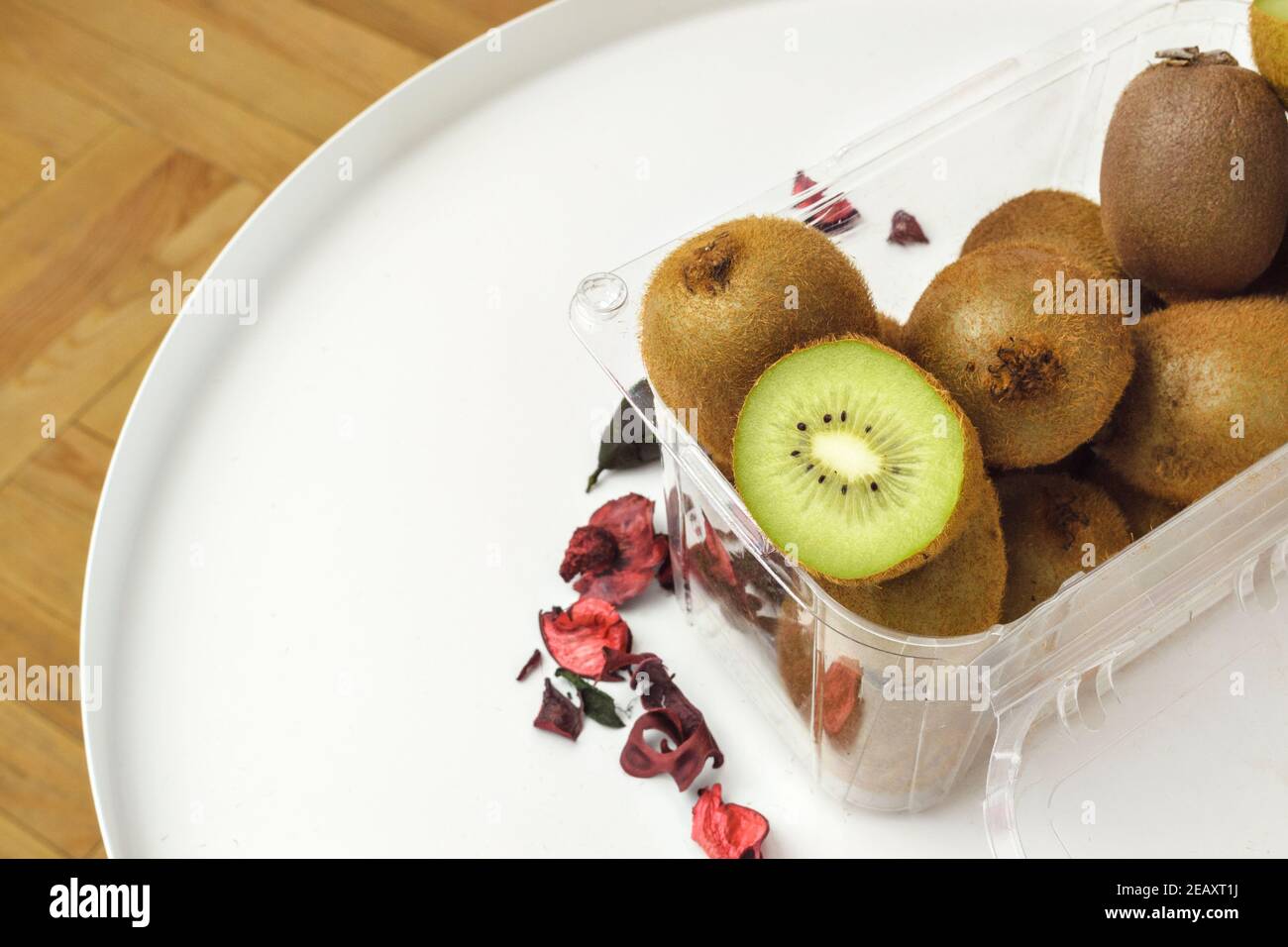 Frische grüne reife Kiwi-Frucht ganz und in Behälter geschnitten Stockfoto