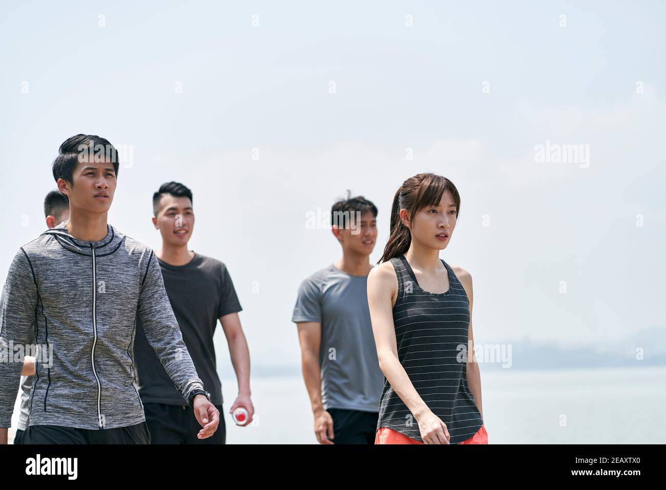 Gruppe von fünf jungen asiatischen Erwachsenen, die einen Spaziergang im Freien Nach dem Training Stockfoto
