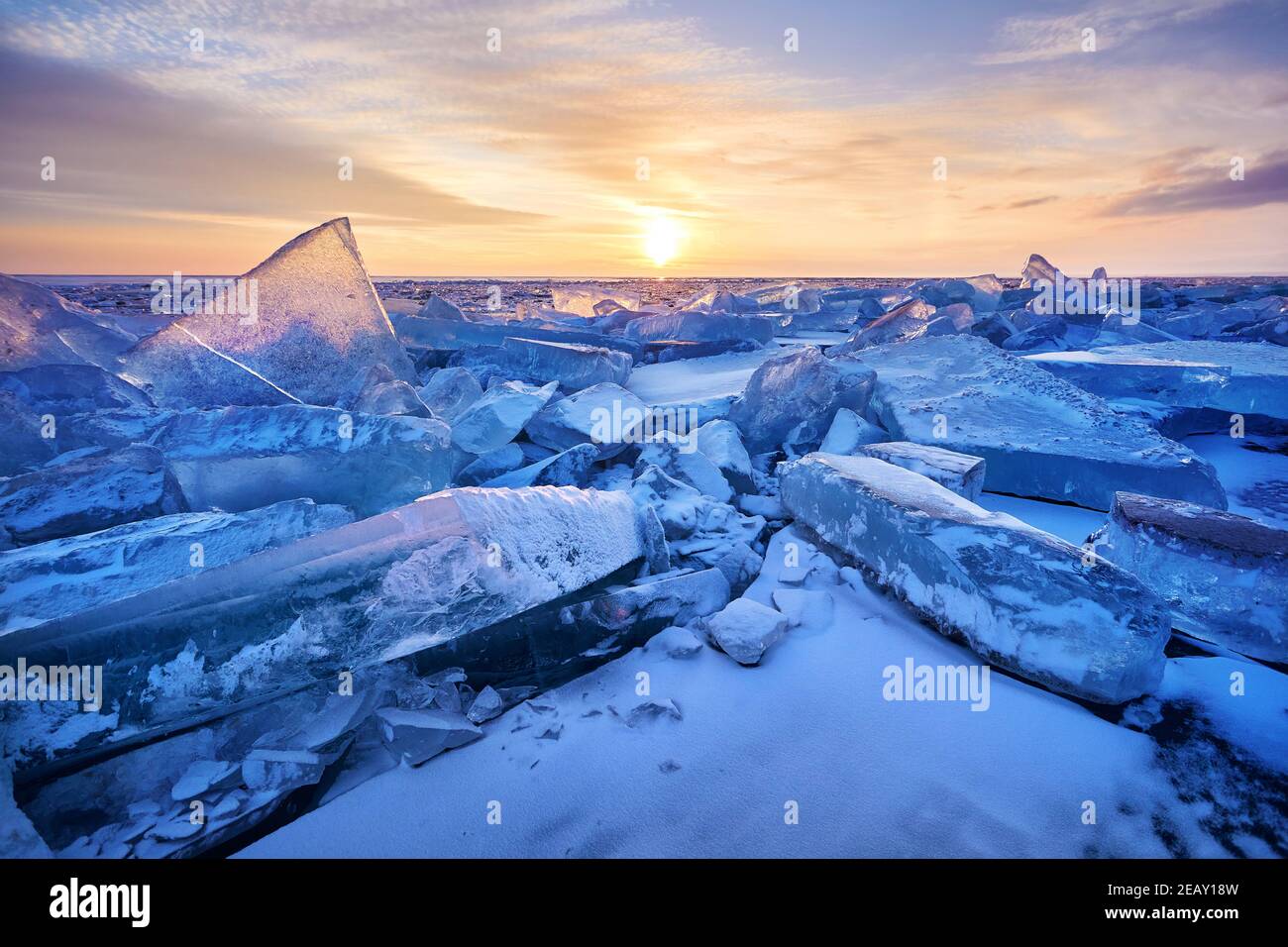 Schöne Landschaft von Eis Hummock mit Lichtreflexe des Sonnenuntergangs am Eis des Baikalsees, Russland Stockfoto