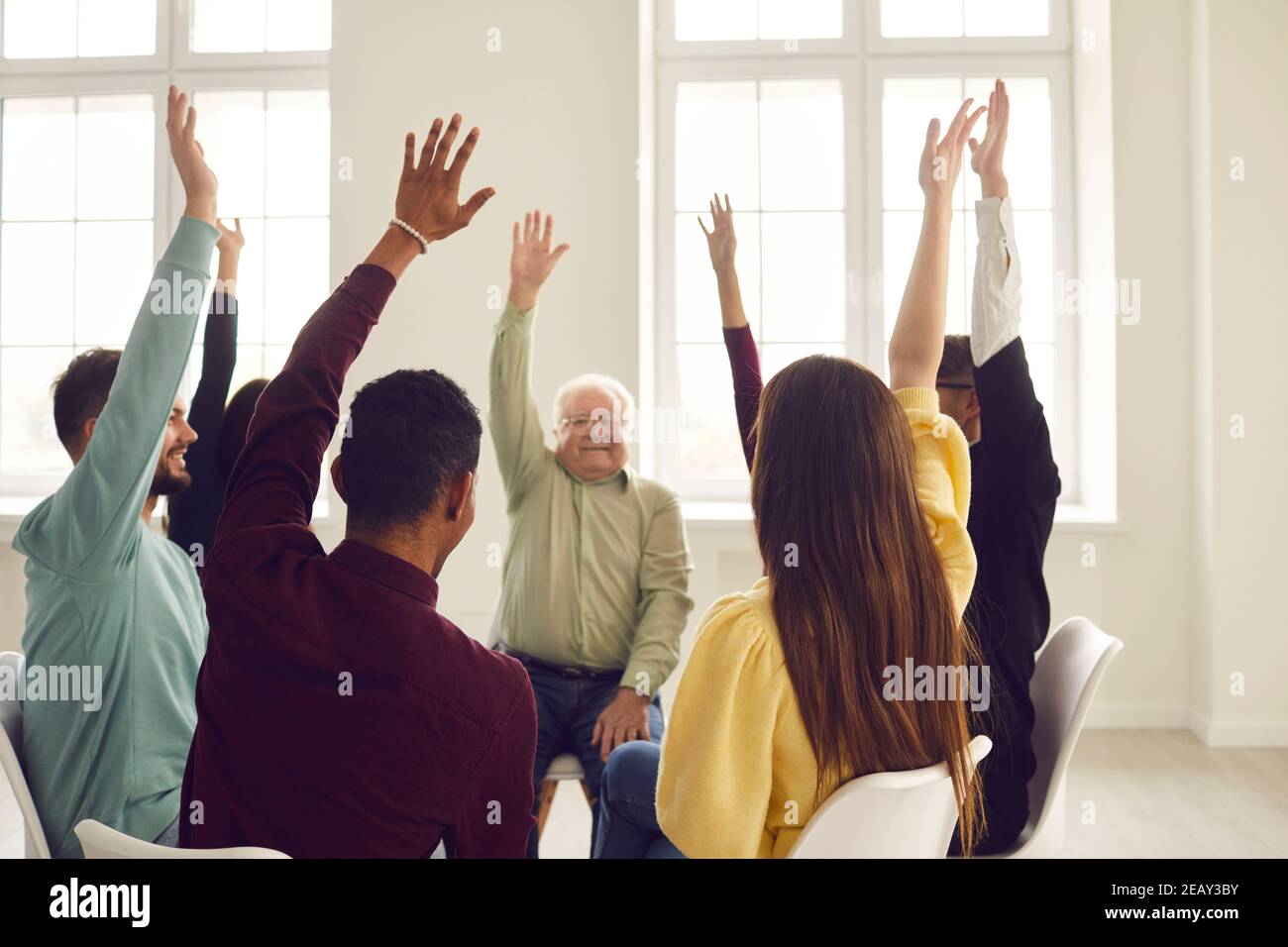 Gruppe von glücklichen Menschen sitzen im Kreis in der Gemeinschaft treffen Und für einen guten Vorschlag stimmen Stockfoto