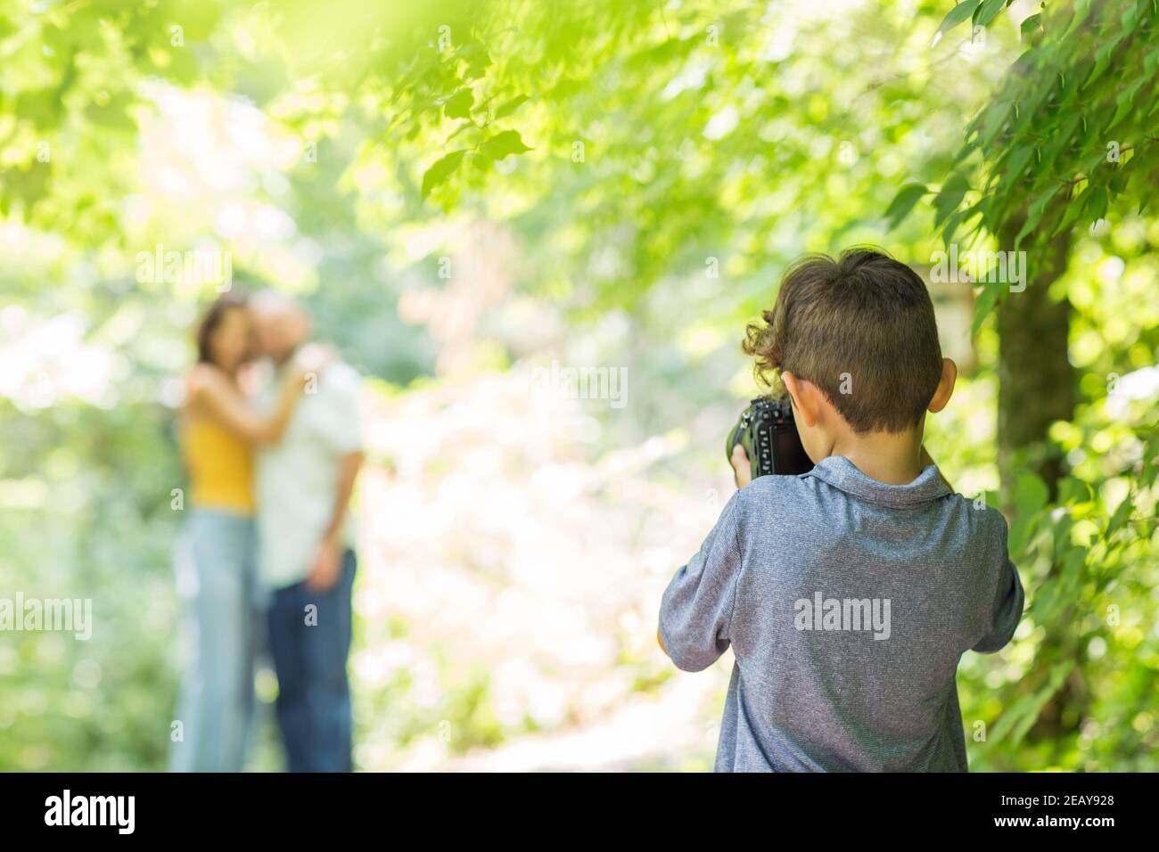 Kleiner Junge, der Fotos von seinen Eltern im Wald machte. Stockfoto
