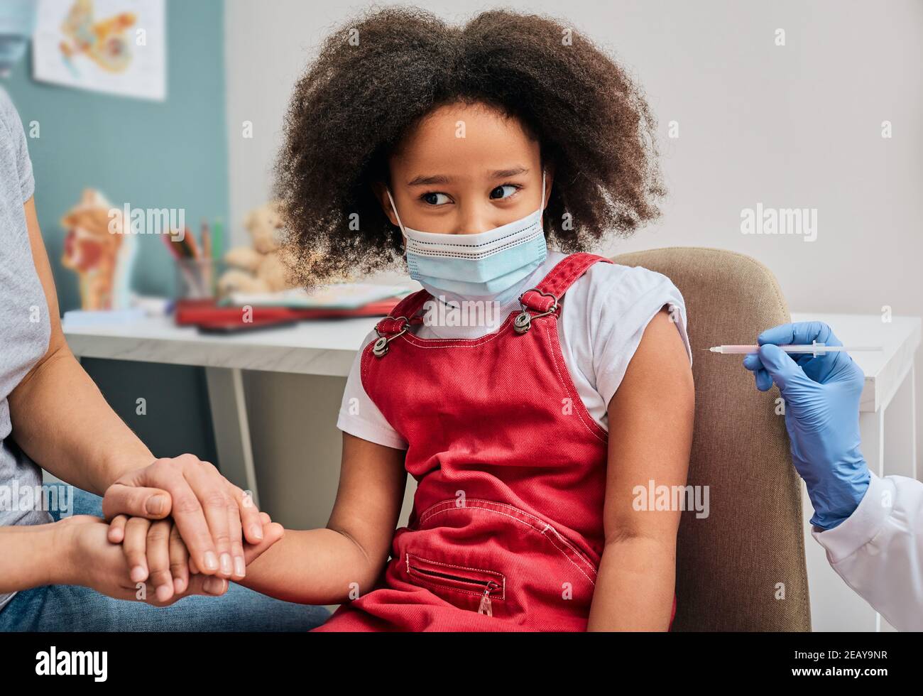 Impfung von Kindern. Afroamerikanisches weibliches Kind während der Impfung in der Arztpraxis. Globale Epidemie Stockfoto