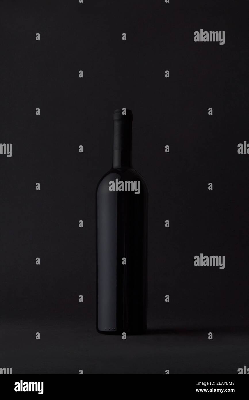 Rote Flasche Luxuswein auf launischem Hintergrund. Stockfoto