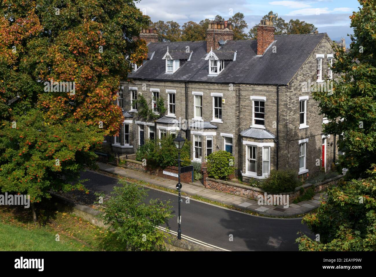 Reihe von malerischen attraktiven weißen Backstein viktorianischen Reihenhäusern, Ende der Terrasse, Straßenschild & Lampe auf Wohnstraße - Bishophill, York, England Großbritannien. Stockfoto