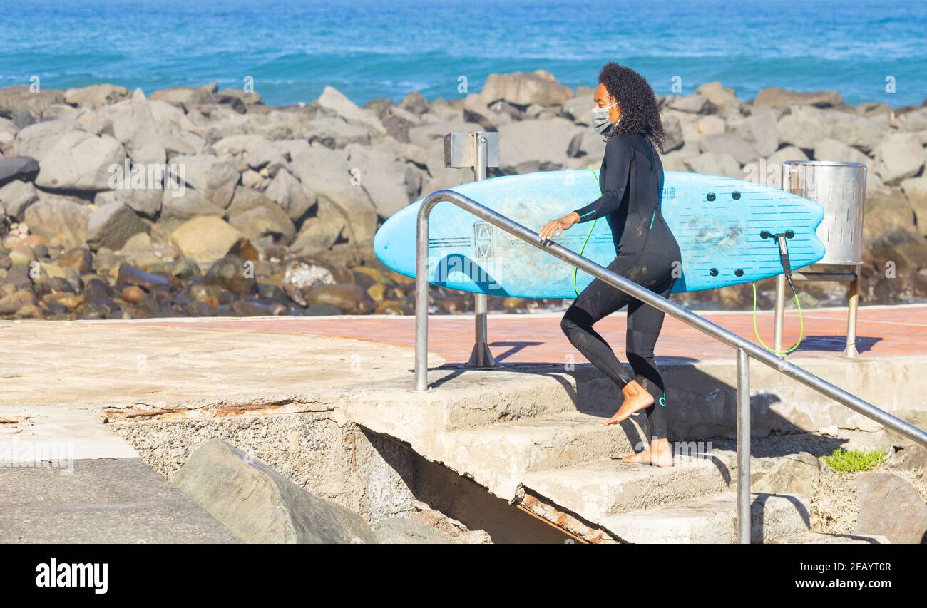 Junge schwarze Hündin, Surferin, Surfen. Stockfoto