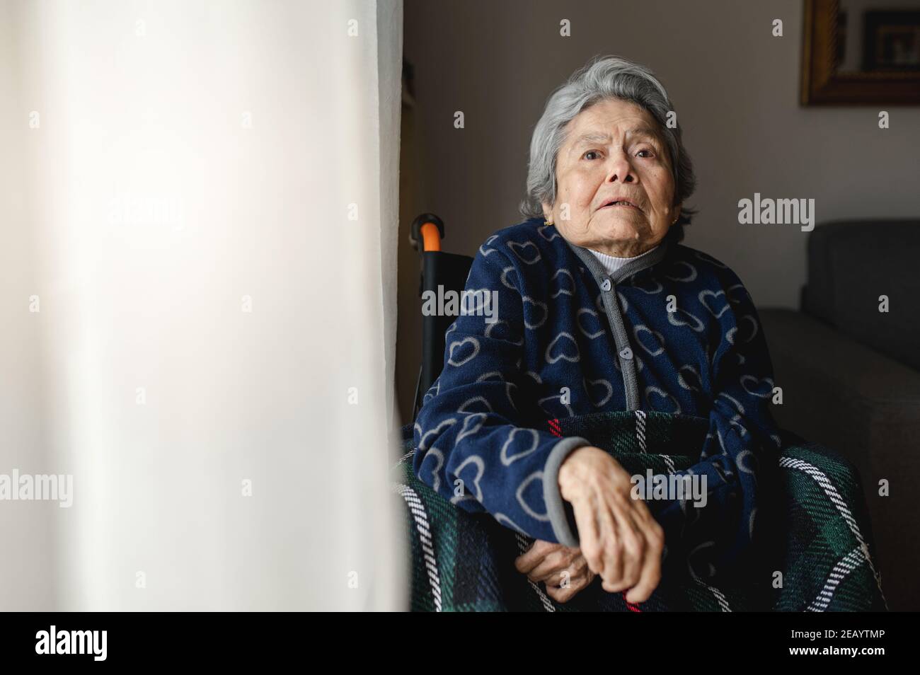 Portrait alte kranke Frau sitzt im Rollstuhl zu Hause mit orientierungslos, verwirrt Gesicht.. Drittes Alter, Heim Ältere Hilfe Konzept. Stockfoto