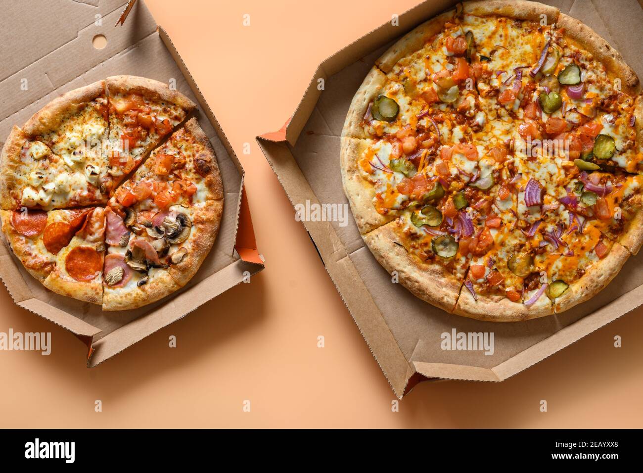 Zwei italienische Pizzen in Kartonschachtel mit Tomaten, Zwiebeln, Mozzarella-Käse, Sauce. Lieferung von Lebensmitteln. Blick von oben. Stockfoto