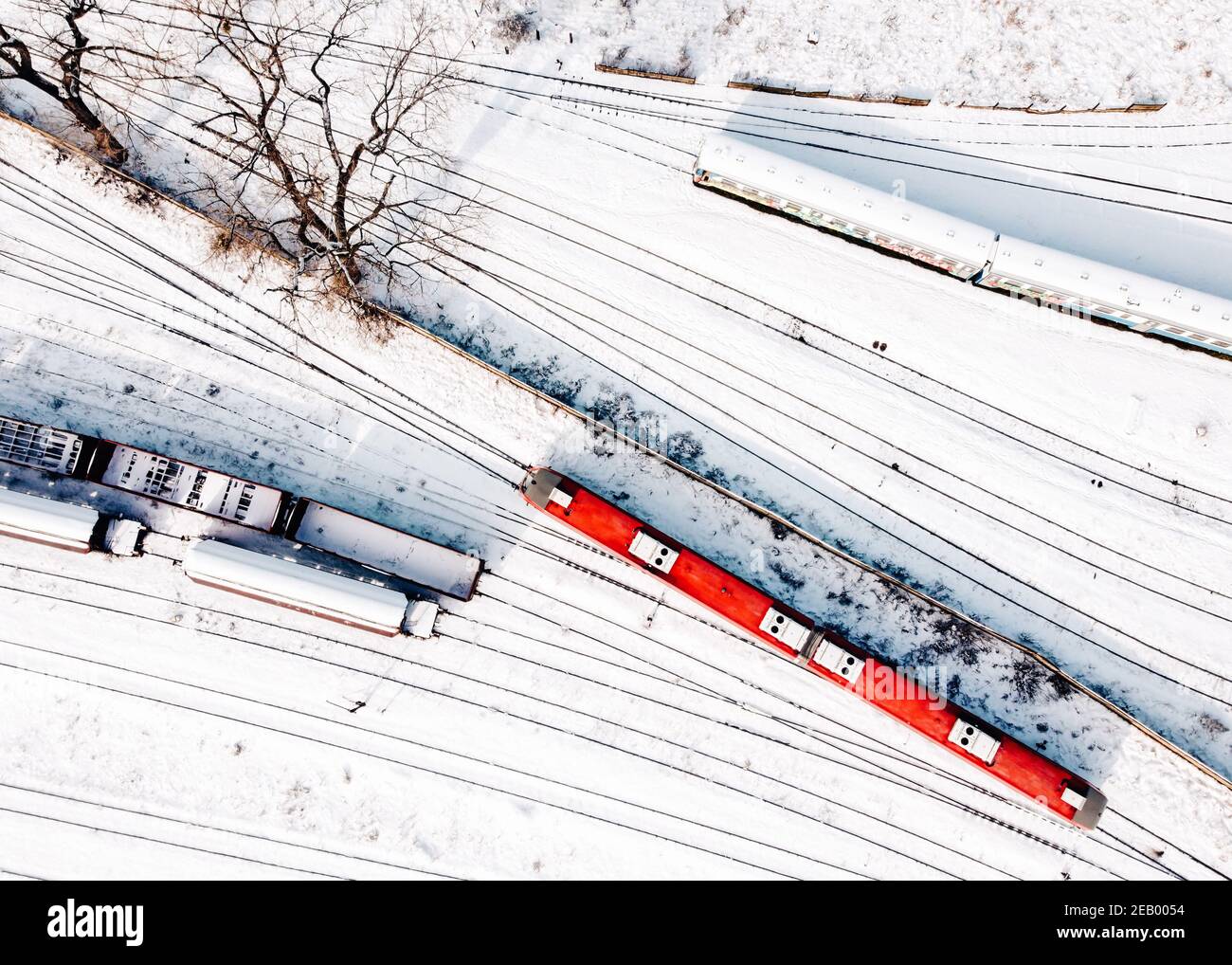 Draufsicht auf Güterzüge und Passanten Diesel-Triebwagen - DMU. Luftaufnahme von der fliegenden Drohne der schneebedeckten Güterzüge auf der Bahn tra Stockfoto