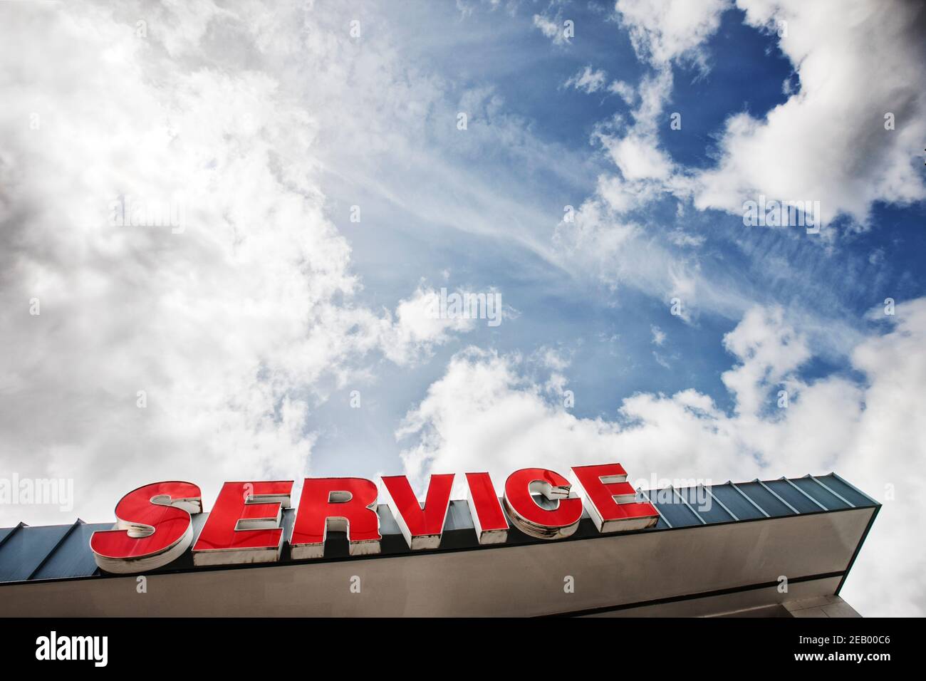Auto-Service-Schild gegen teilweise bewölkten blauen Himmel aus gesehen Unten Stockfoto