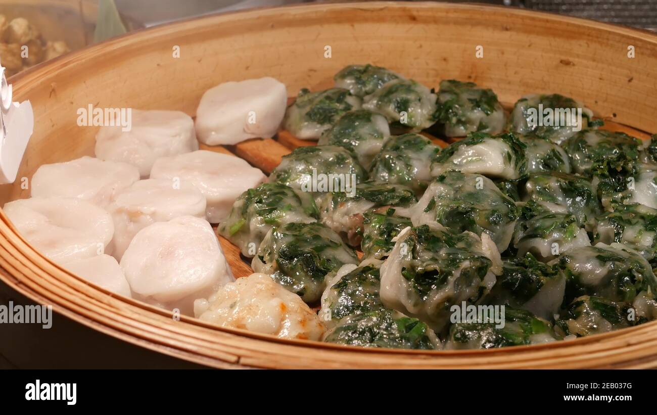 Schüssel mit heißen asiatischen Knödeln. Holzschüssel mit köstlichen traditionellen Thai Knödel auf Stand in der Straße Diner platziert. Stockfoto