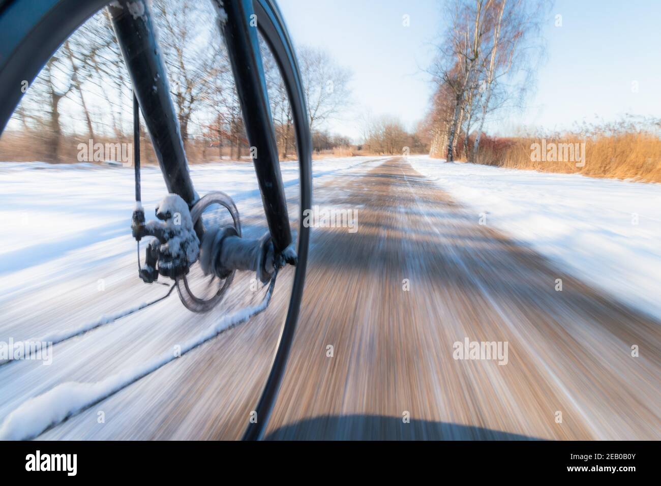 Vordere Fahrrad Rad drehen Bewegung Unschärfe. Radfahren auf rutschigem Schnee Stockfoto