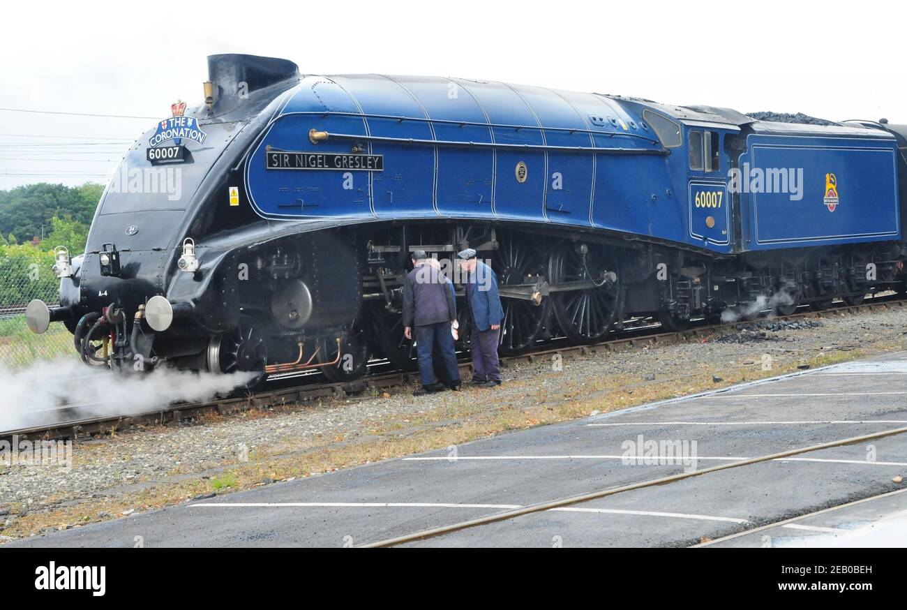 Die Besatzung der Klasse A4 Pacific No 60007 'Sir Nigel Gresley' inspiziert die Lokomotive in York, nachdem sie die Krönungseisenbahn-Tour von Tyne Yard aus gezogen hat. Stockfoto