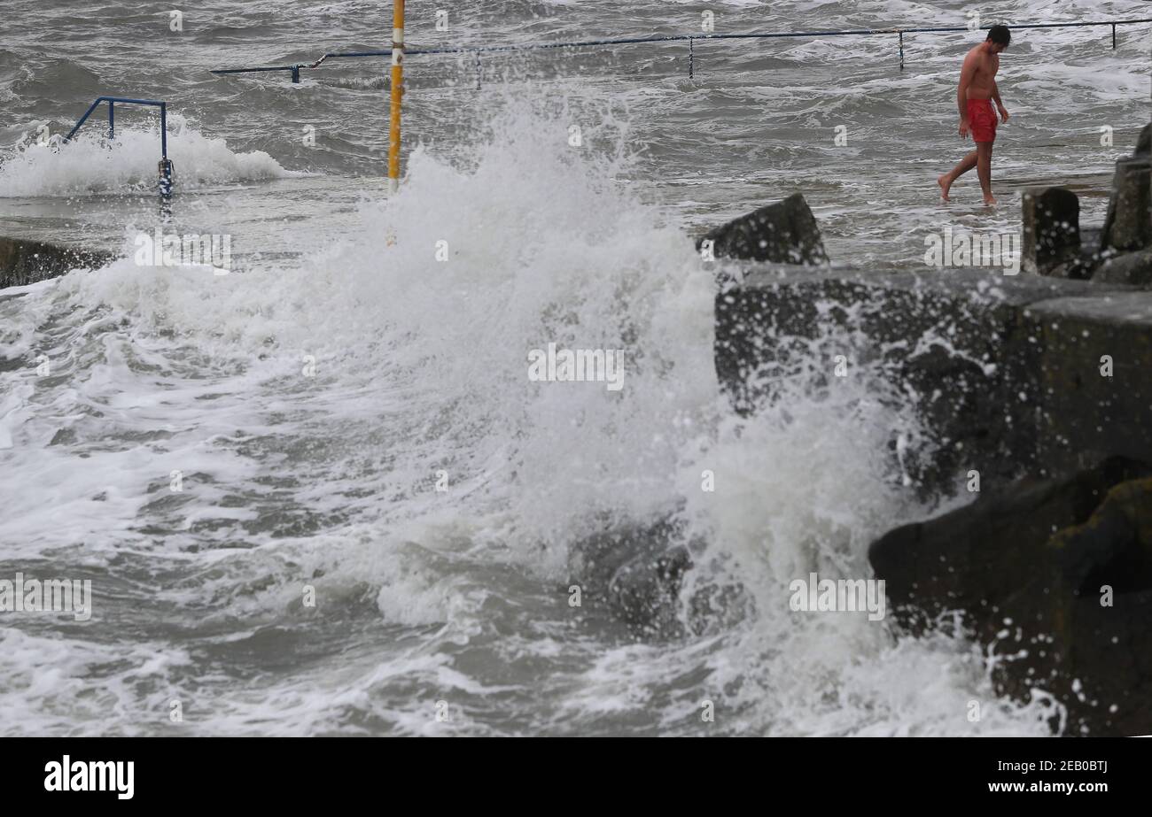 Eine Schwimmerin in Seapoint in Dublin hat als Met Eireann zwei Wetterwarnungen herausgegeben, darunter starke bis orkanartige Südostwinde in Verbindung mit Regen, Schneeregen und Schnee. Bilddatum: Donnerstag, 11. Februar 2021. Stockfoto