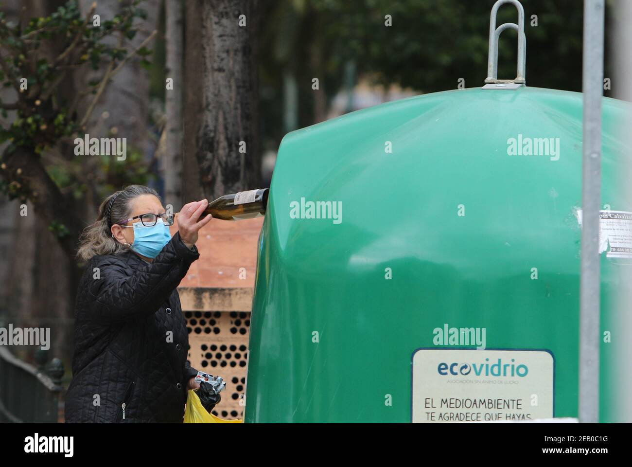 11. Februar 2021: 11. Februar 2021 (Malaga) EINE Frau recycelt Glasflasche und Karton Kredit: Lorenzo Carnero/ZUMA Wire/Alamy Live News Stockfoto