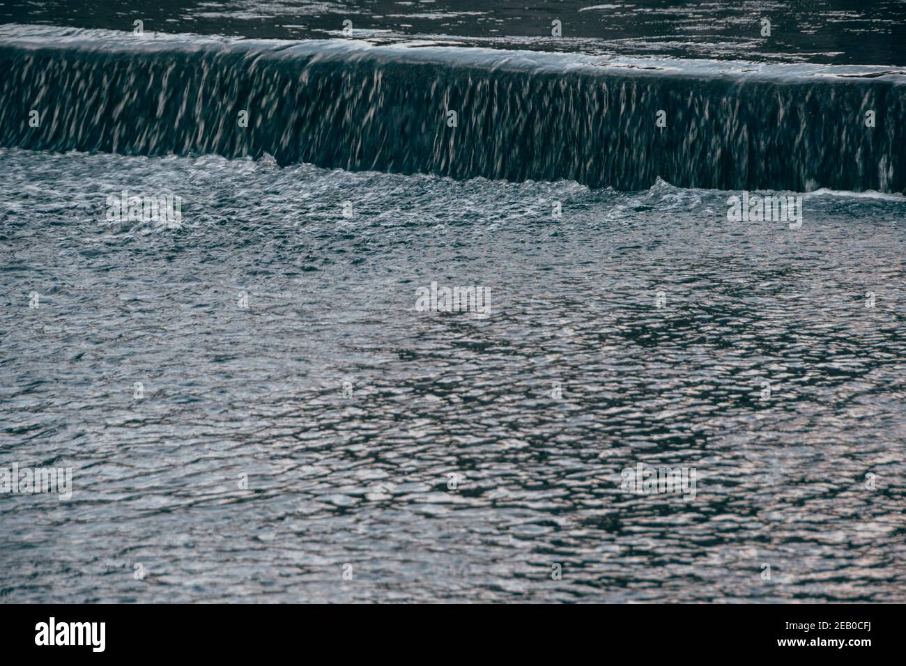 Breiter Fluss am Sommertag. Wasserfluss auf dem Damm Stockfoto