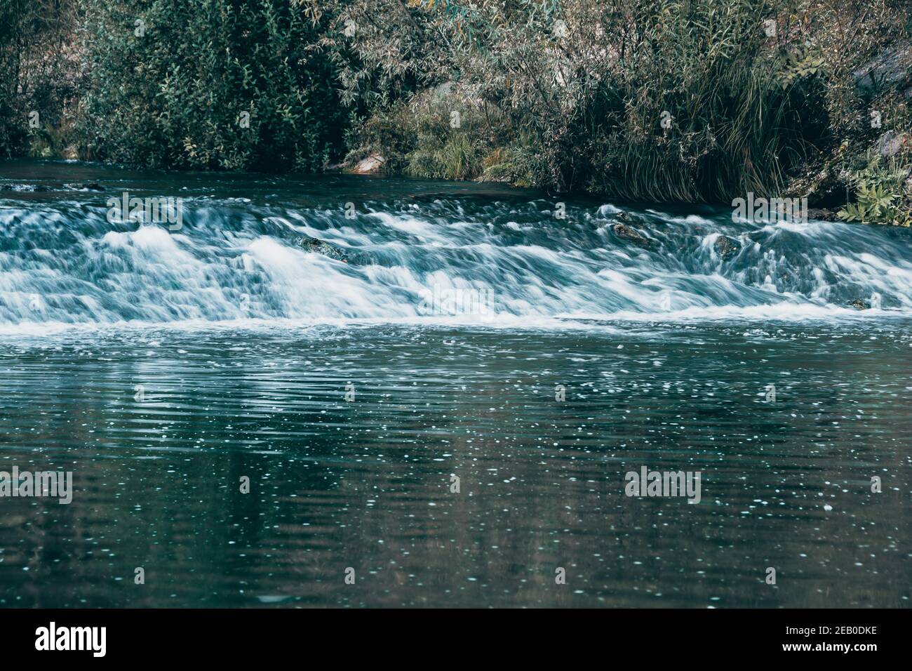Breiter Fluss am Sommertag. Wasserfluss auf dem Damm Stockfoto