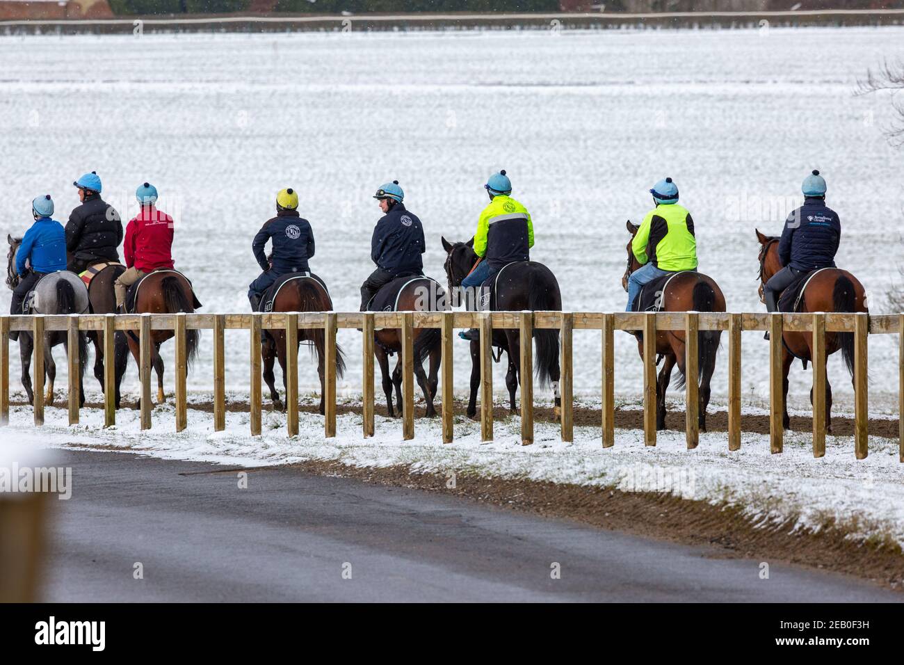 Bild vom 9th. Februar zeigt Jockeys und Rennpferde beim Training auf der Allwetterstrecke in Newmarket, Suffolk, am Dienstagmorgen bei eisigen Temperaturen und umliegender Schneedecke.Mehr Schnee und Regen werden für die nächsten 48 Stunden prognostiziert, da Sturm Darcy weiterhin schlechtes Wetter in Teile des Landes bringt. Stockfoto