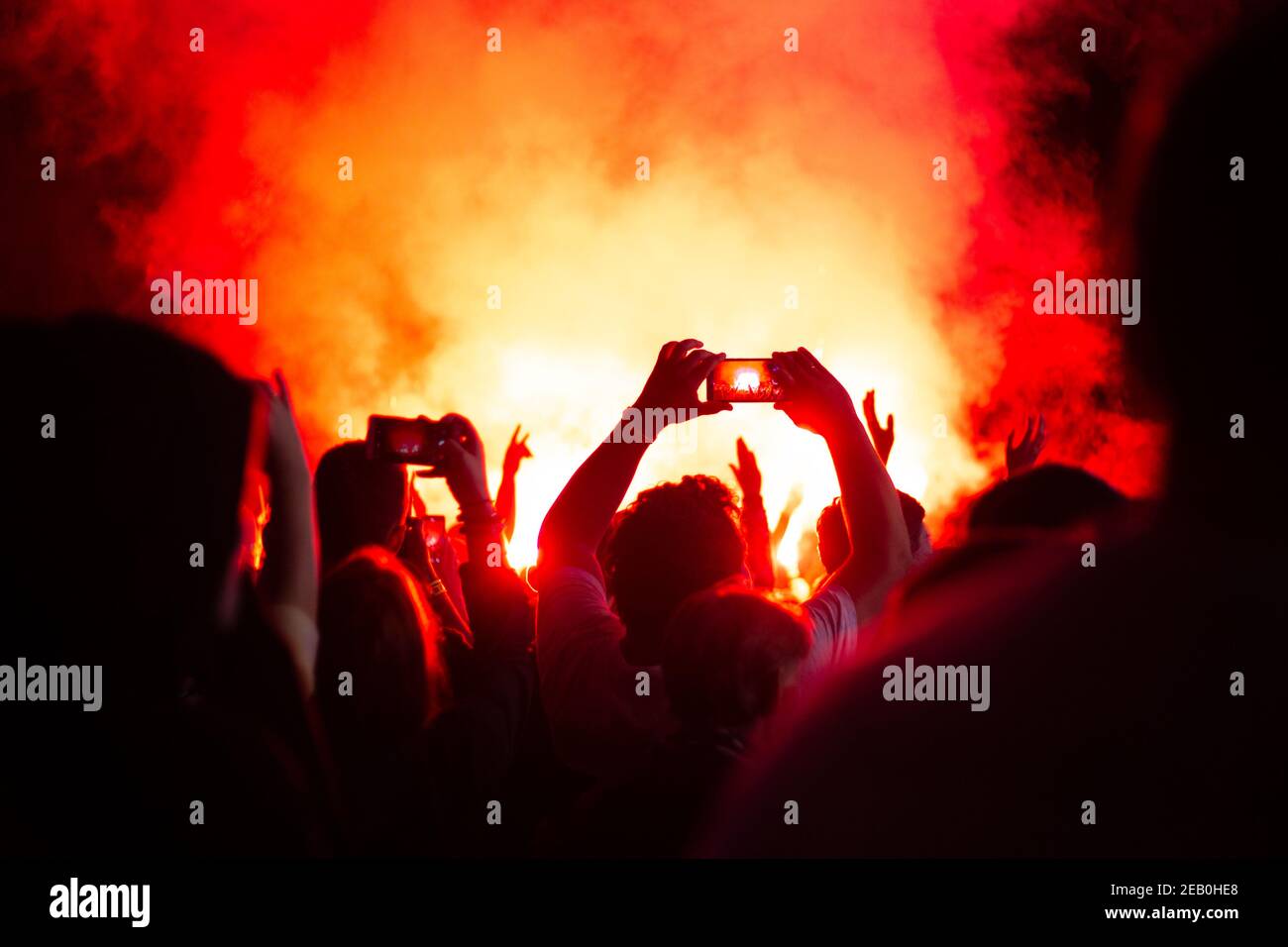 Heftiges Feuer in der Nacht schießt eine Menschenmenge Videos am Telefon, helles Feuer und schwarzen Rauch Stockfoto