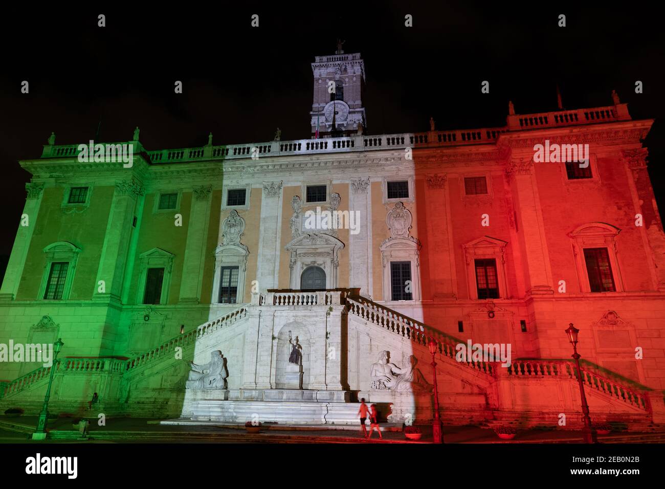 Senatorenpalast (Palazzo Senatorio) bei Nacht, Piazza del Campidoglio auf dem Kapitolinischen Hügel in Rom, Italien, in italienischen Farben beleuchtet, doppelte Rampe Stockfoto