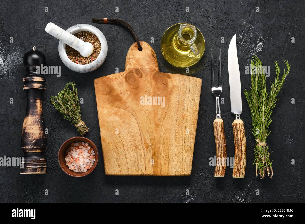 Overhead-Ansicht von leeren Holz Schneidebrett mit Gewürz für Steak, Messer und Gabel mit Horngriff Stockfoto