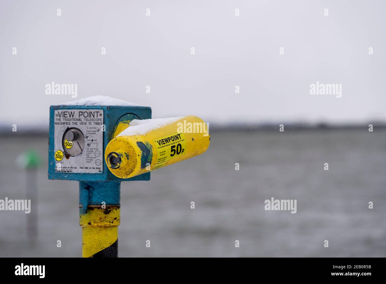 Altes Münzfernrohr an der Küste in Southend on Sea, Essex, Großbritannien, mit Schnee von Storm Darcy. Blickpunkt. 50p Stockfoto