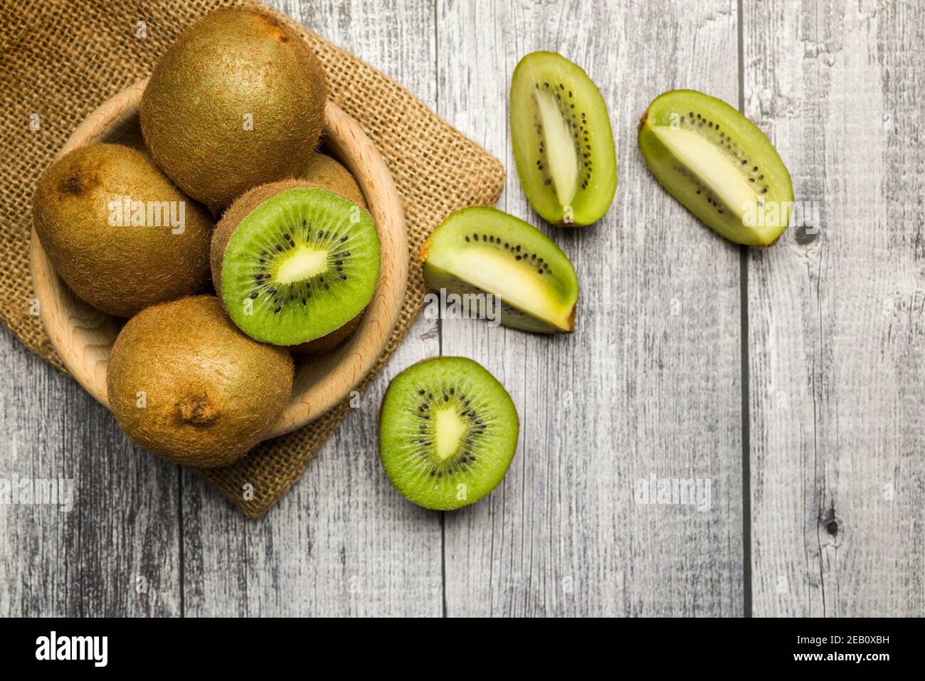 Draufsicht Kiwi Früchte auf Schüssel mit Scheiben auf Holz Tabelle Stockfoto