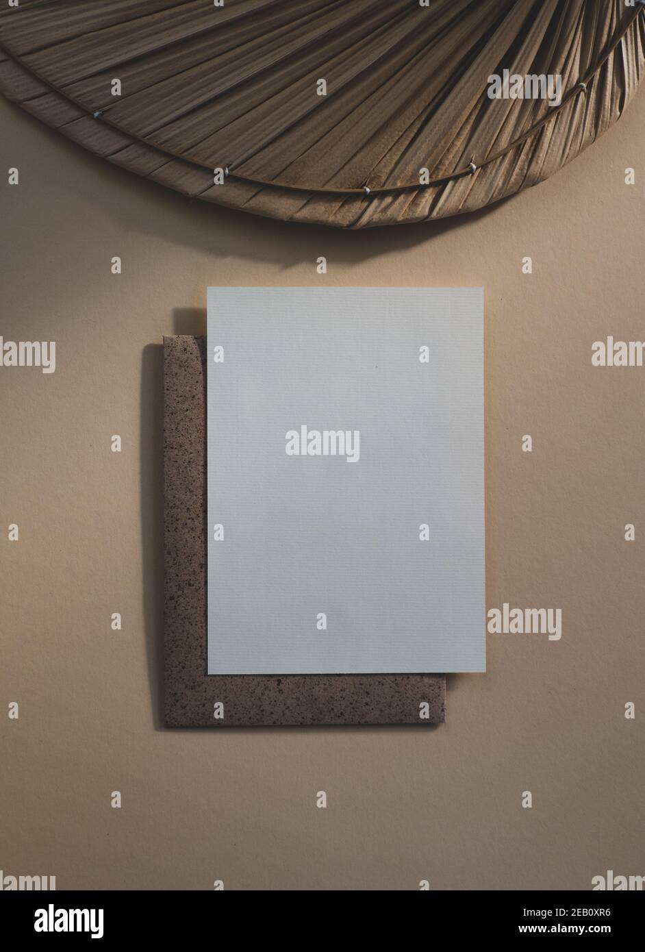 Leere, weiße, leere ungestrichene Papierkarte isoliert auf beigem Boho-Stil Hintergrund Stockfoto