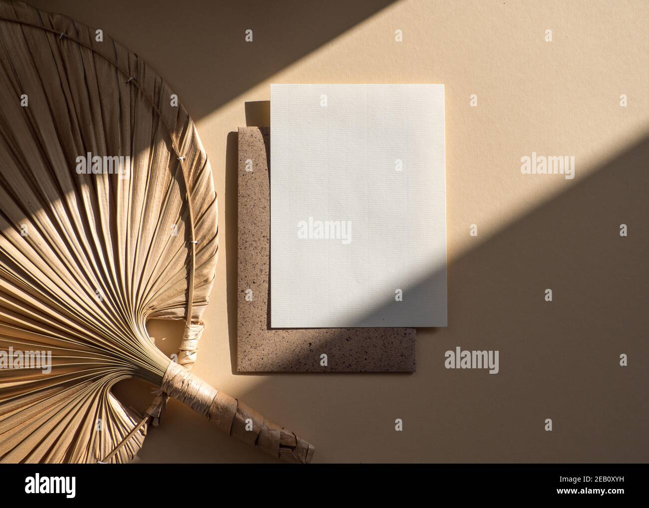 Leere, weiße, leere ungestrichene Papierkarte isoliert auf beigem Boho-Stil Hintergrund Stockfoto