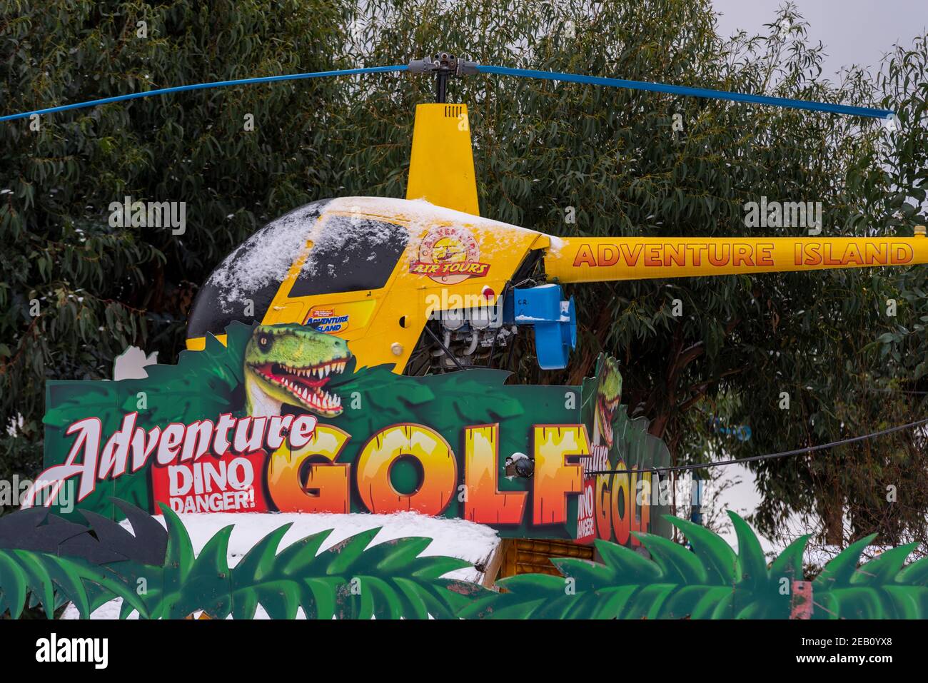Helikopter-Schild im Adventure Island Themenpark in Southend on Sea, Essex, Großbritannien, mit Schnee von Storm Darcy. Dino Danger Golf. Robinson R22 Hubschrauber Stockfoto