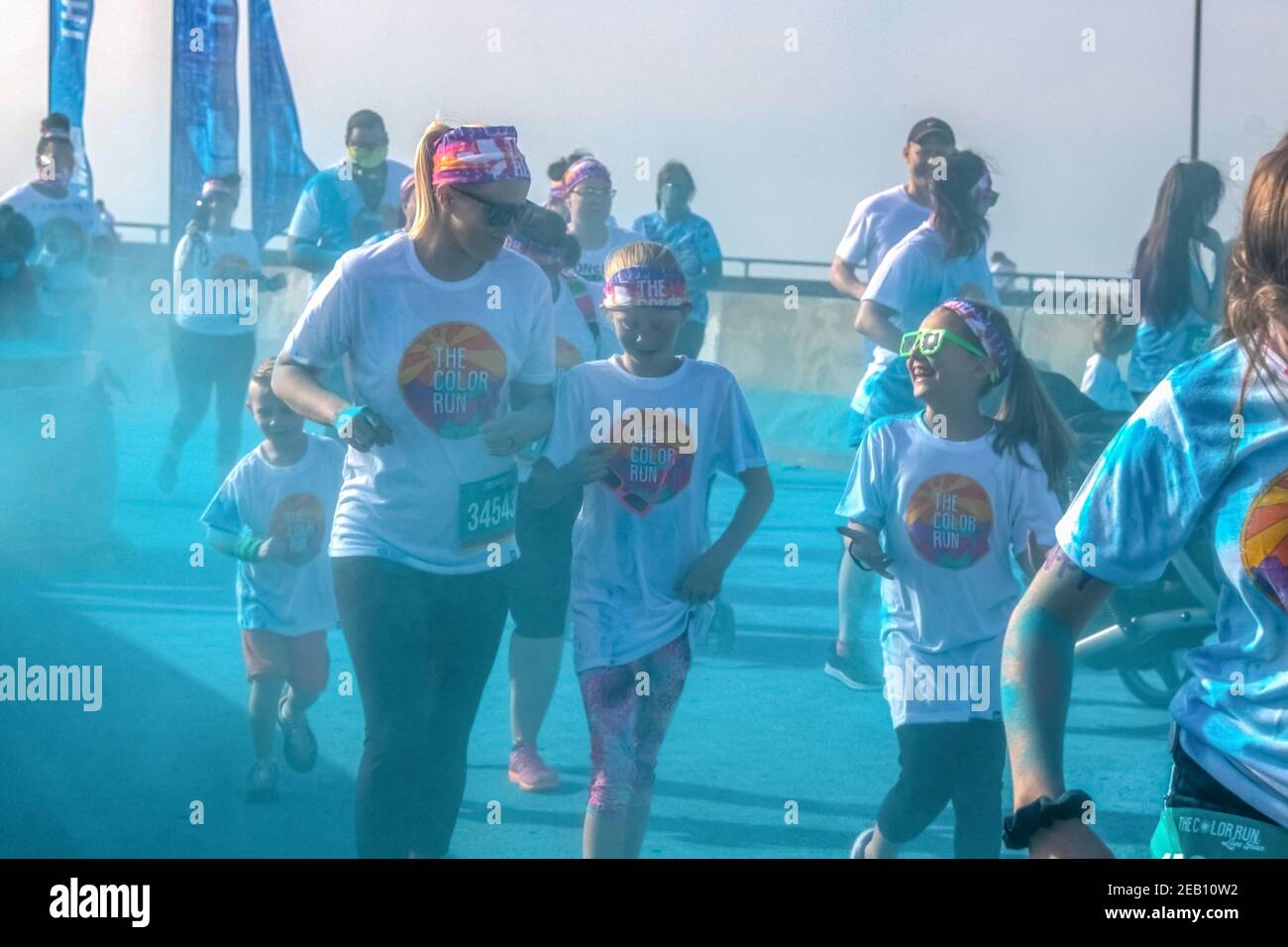 April 6 2019 Tulsa USA Mutter und Kinder laufen lachend Durch blaues Pulver an der Farbstation bei Color - holi Run - sieht körnig und verschwommen aus, weil Stockfoto