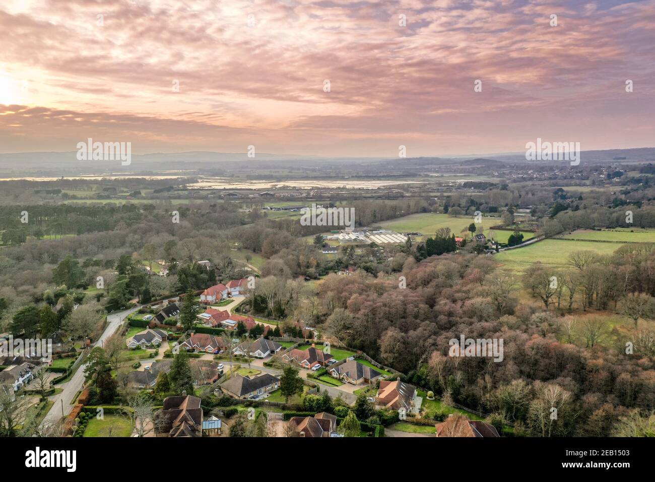 Luftdrohnenaufnahme eines ländlichen Dorfes in West Sussex, England. Große Wohnanlage mit Gärten unter den South Downs im Winter. Stockfoto