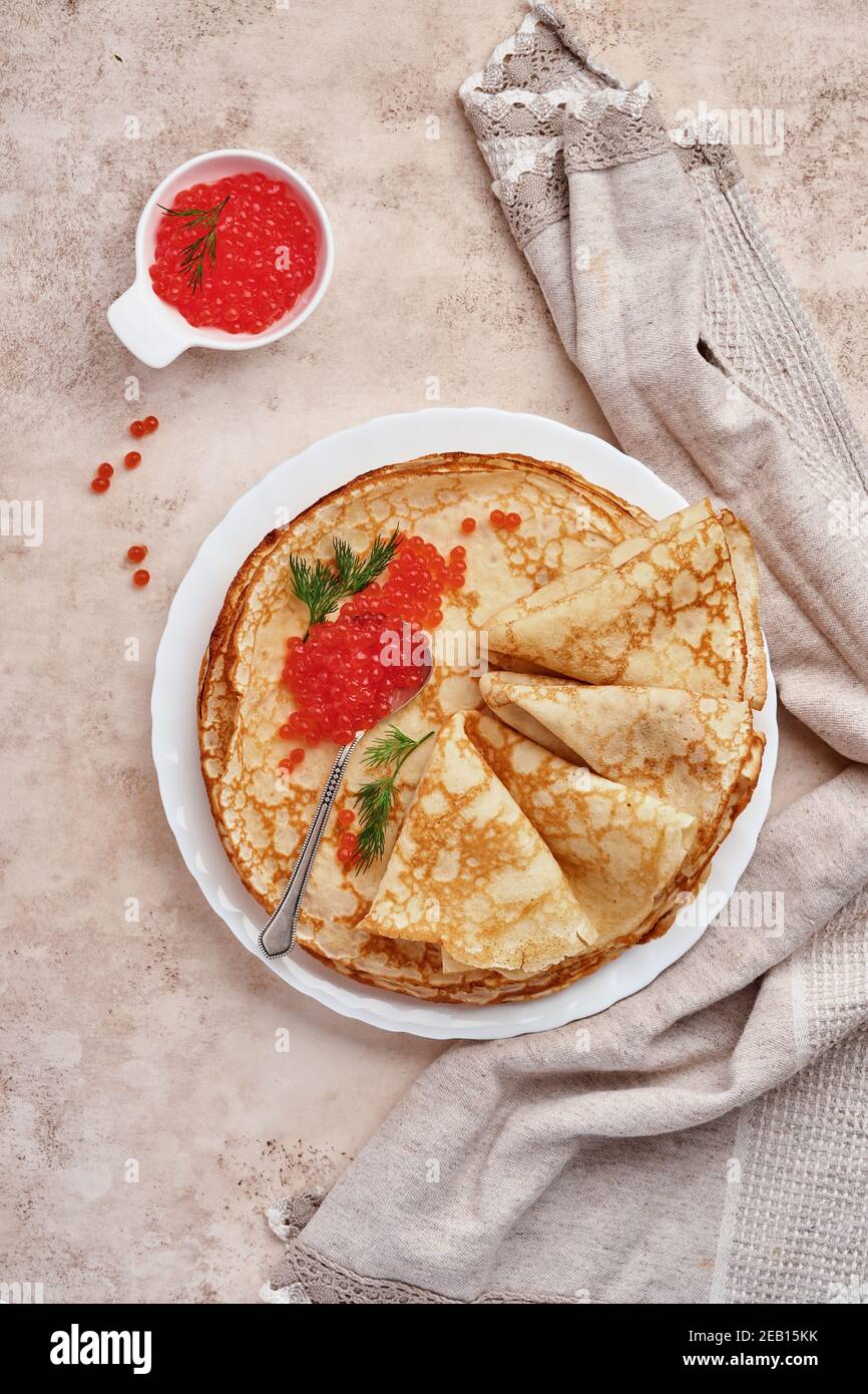 Crepes, dünne Pfannkuchen, russische Pfannkuchen mit rotem Kaviar auf grauem Teller. Marmorhintergrund. Speicherplatz kopieren. Draufsicht. Stockfoto