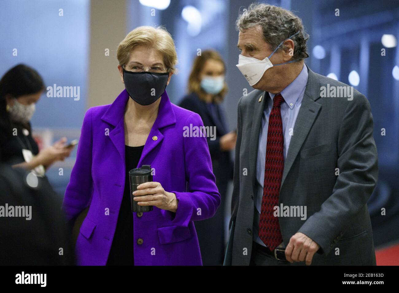 Washington, Usa. Februar 2021, 11th. Senatorin Elizabeth Warren, Demokratin aus Massachusetts, und Senator Sherrod Brown, Demokratin aus Ohio, tragen Schutzmasken, während sie am dritten Tag des zweiten Amtsenthebungsverfahrens am Kapitol in Washington, DC, am Donnerstag, dem 11. Februar 2021 durch die Senatsbahn im US-Kapitol gingen. Argumente werden heute im Amtsenthebungsverfahren gegen den ehemaligen Präsidenten Donald Trump präsentiert. Pool Foto von Ting Shen/UPI Kredit: UPI/Alamy Live Nachrichten Stockfoto