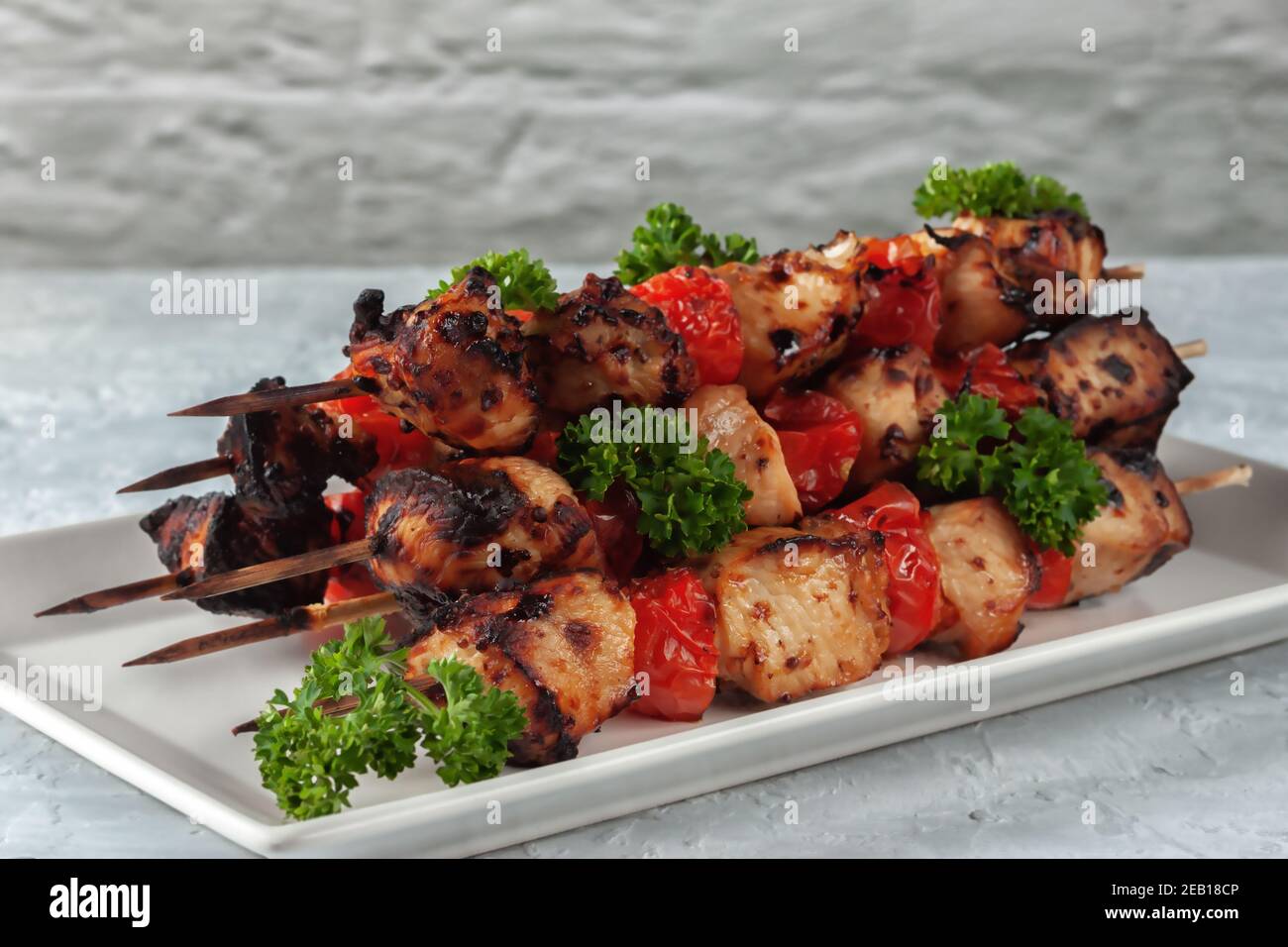 Auf einem grauen Hintergrund Grill von Huhn auf Spieße mit Gemüse Stockfoto