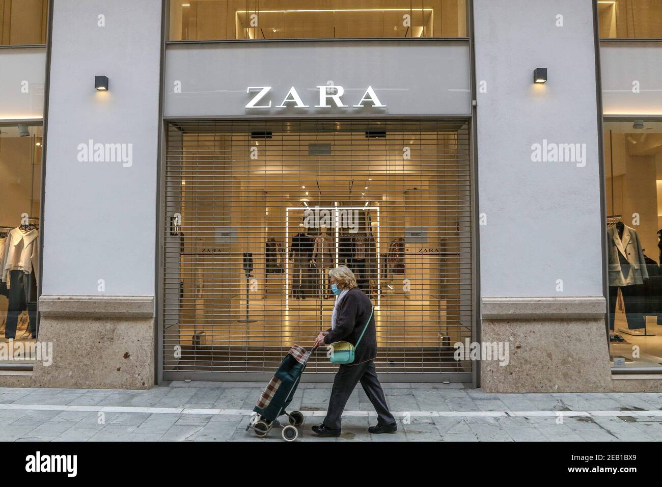 11. Februar 2021 (Malaga) EINE Frau geht vor einem Zara-Geschäft des Geschäftsmannes Amancio Ortega, das geschlossen ist, weil es kein wesentlicher Handel ist.Quelle: CORDON PRESS/Alamy Live News Stockfoto