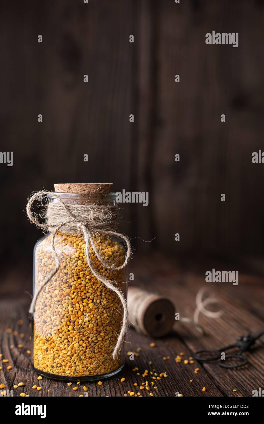 Gesundes Nahrungsergänzungsmittel, Superfood Bienenpollen in einer Glasflasche mit Kopie auf rustikalem Holzhintergrund Stockfoto