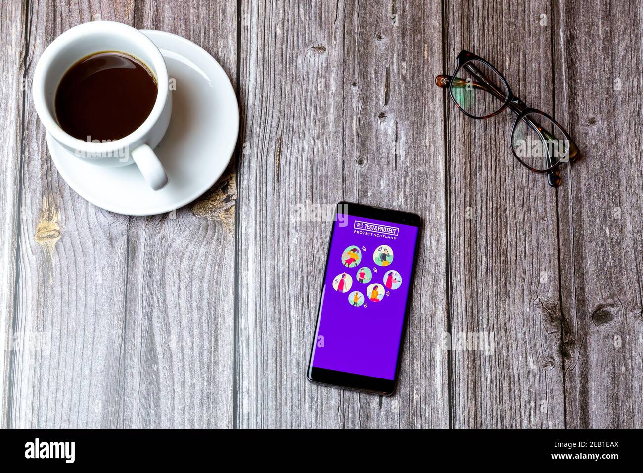 Ein Handy oder Handy auf einem Holz gelegt Tabelle mit der Test and Protect Scotland App geöffnet auf Angezeigt Stockfoto