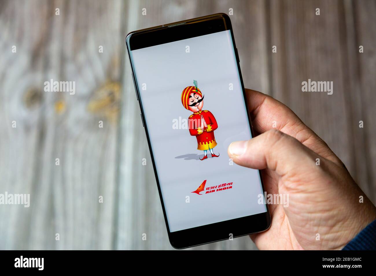 Ein Mobiltelefon oder Mobiltelefon, das von einem gehalten wird Hand mit der Air India App auf dem Bildschirm geöffnet Stockfoto