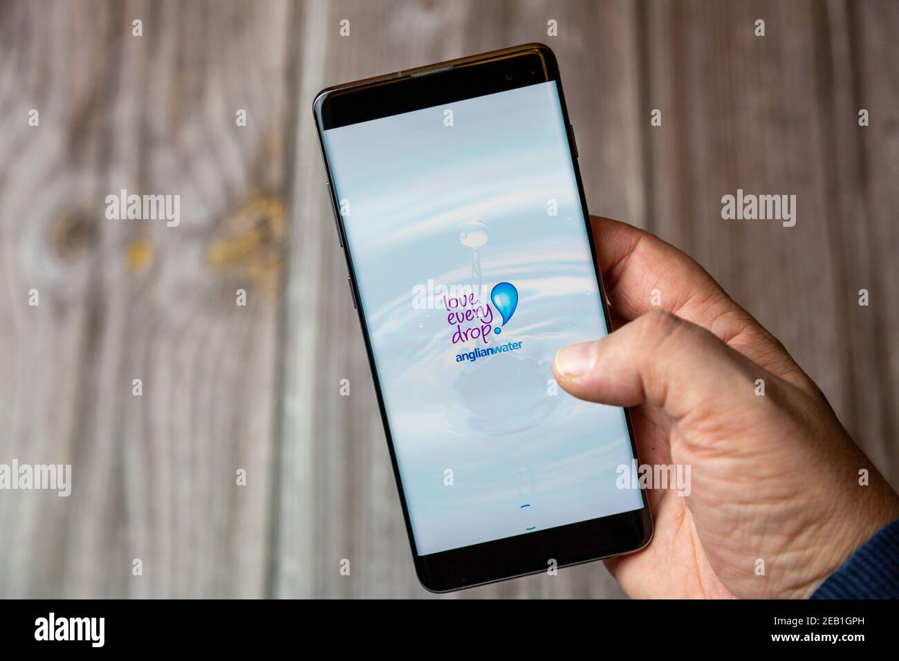 Ein Mobiltelefon oder Mobiltelefon, das von einem gehalten wird Hand mit der Anglian Wasser-App auf dem Bildschirm geöffnet Stockfoto