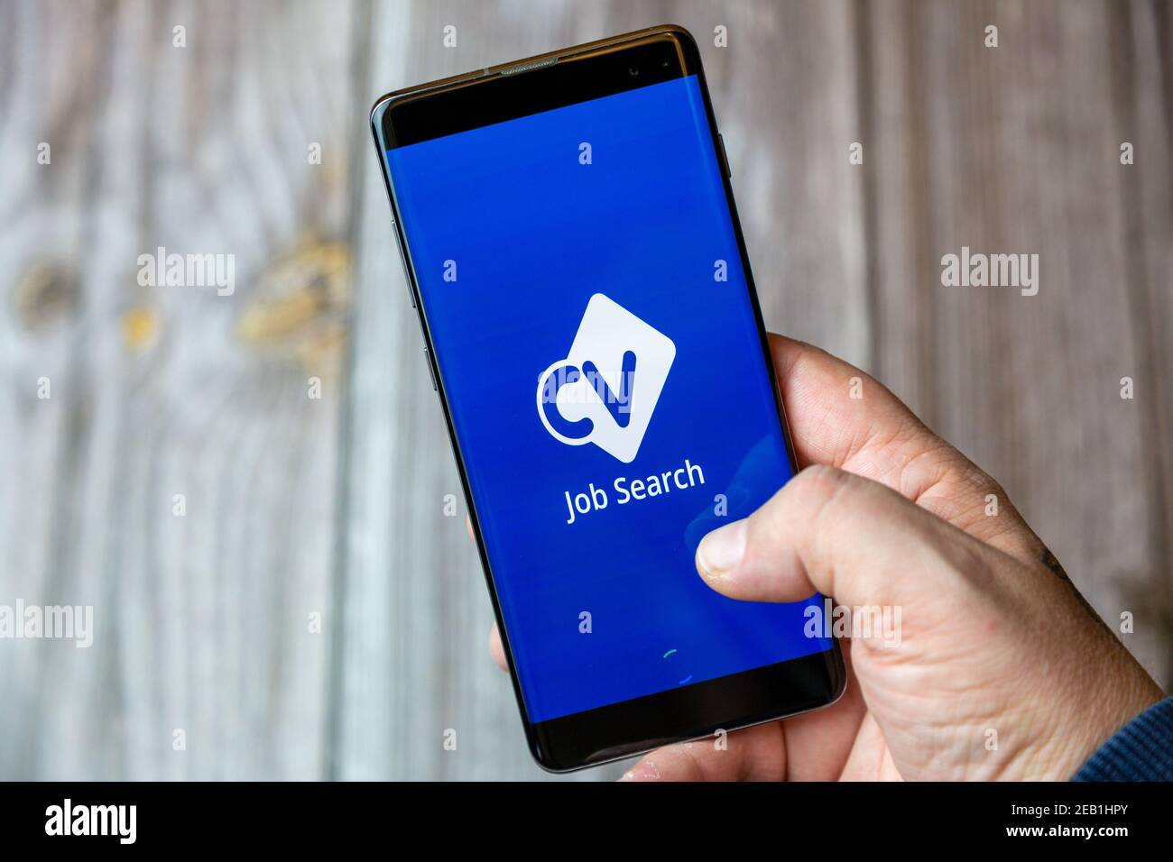 Ein Mobiltelefon oder Mobiltelefon, das von einem gehalten wird Hand mit der CV Library Jobsearch App auf dem Bildschirm geöffnet Stockfoto