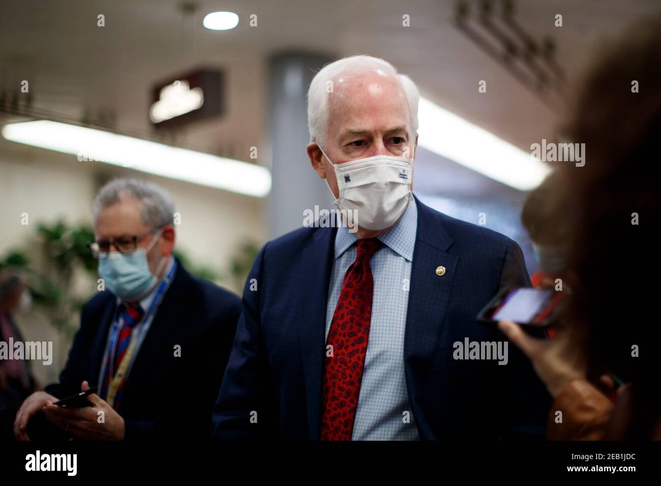 Senator John Cornyn, ein Republikaner aus Texas, trägt eine Schutzmaske, während er am Donnerstag, den 11. Februar 2021, mit Pressemitgliedern in der Senate Subway im US-Kapitol in Washington, DC, USA, spricht. Die Staatsanwälte des Hauses nutzten den zweiten Tag von Donald Trumps Amtsenthebungsverfahren, um eine monatelange Kampagne des ehemaligen Präsidenten detailliert zu beschreiben, um Hass zu schüren und Gewalt über die Wahlergebnisse zu fördern, die sie sagten, gipfelten in dem Mobangriff auf das US-Kapitol, das er dann wenig getan habe, um zu stoppen. Quelle: Ting Shen - Pool via CNP - Nutzung weltweit Stockfoto