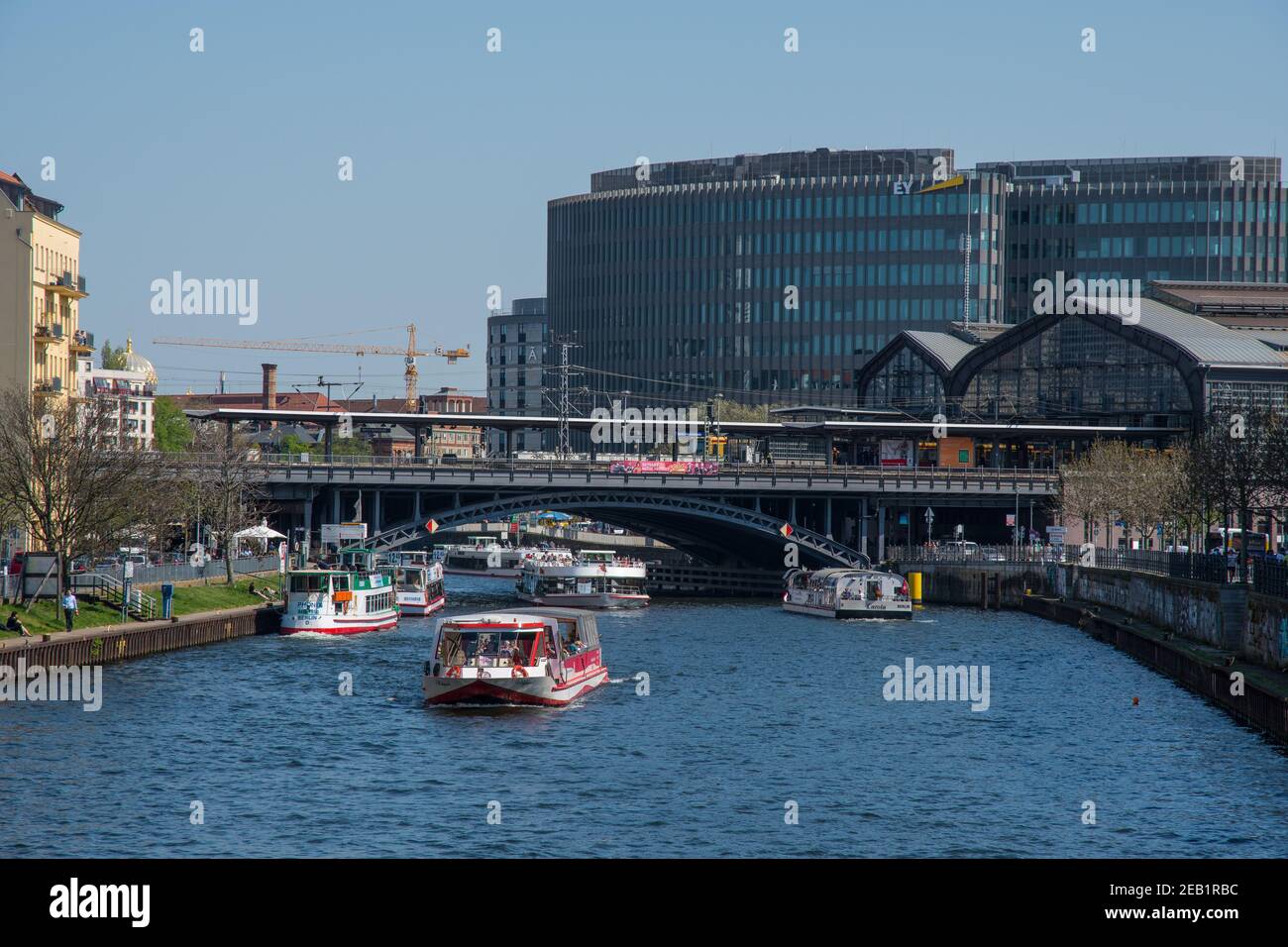 Berlin Deutschland - April 20. 2018: Ausflugsboote auf der Spree mit Bahnhof und Gebäuden im Hintergrund Stockfoto